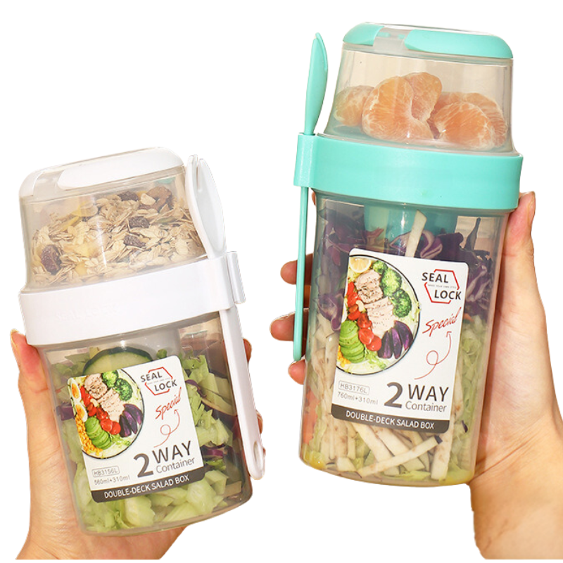 Dual-layer meal container with a spoon, featuring two compartments for organized food storage, ideal for lunches and meal prep.