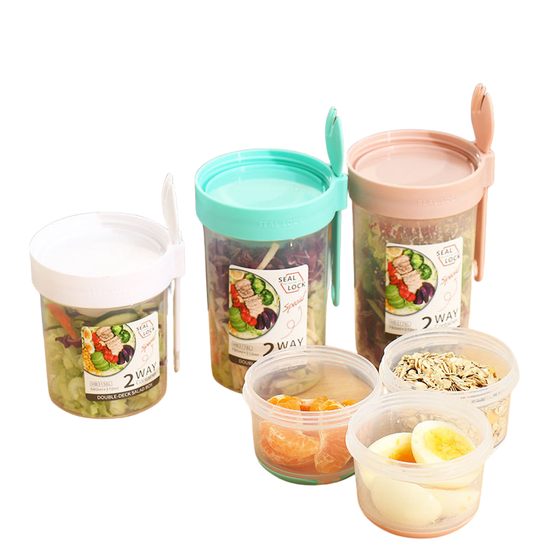 Dual-layer meal container with a spoon, featuring two compartments for organized food storage, ideal for lunches and meal prep.